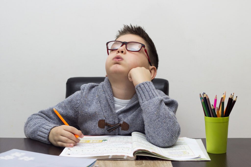 young boy frustrated homework writing home boy studying table kid drawing with pencil